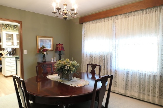 carpeted dining room featuring a notable chandelier and a wealth of natural light