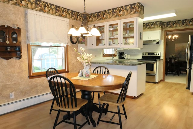 dining space featuring light hardwood / wood-style flooring, a baseboard radiator, and a notable chandelier