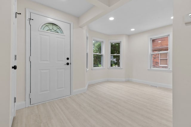 entrance foyer featuring beam ceiling, light hardwood / wood-style flooring, and plenty of natural light