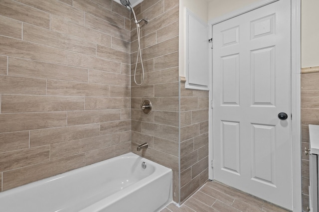 bathroom featuring wood-type flooring, tile walls, and tiled shower / bath