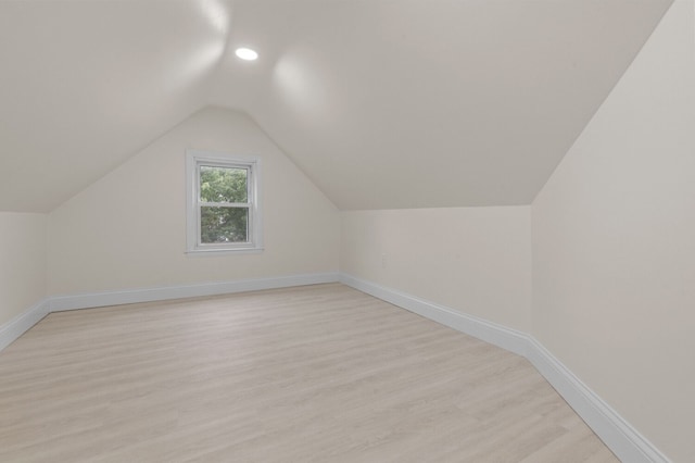 additional living space featuring light hardwood / wood-style floors and lofted ceiling