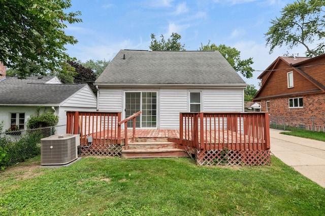 back of property with a yard, cooling unit, and a wooden deck