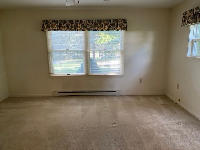 carpeted empty room with ceiling fan and a baseboard heating unit