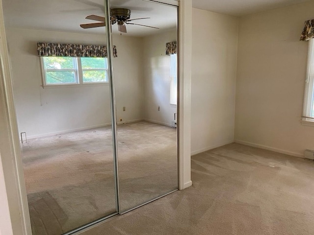 unfurnished bedroom with ceiling fan, a closet, and light carpet