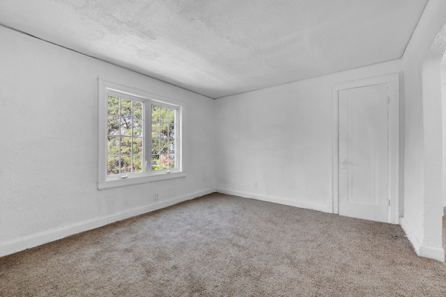 carpeted spare room with a textured ceiling