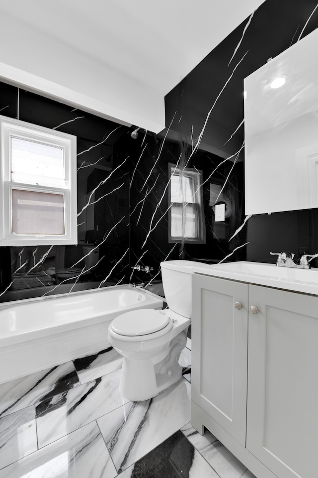 full bathroom with vanity, tub / shower combination, toilet, and tile walls