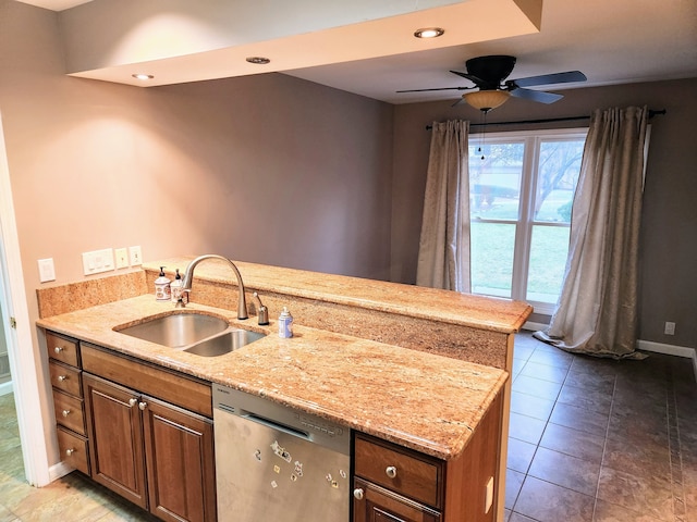 kitchen with tile patterned flooring, dishwasher, light stone countertops, and sink