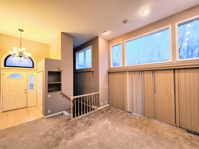 carpeted entryway featuring a chandelier