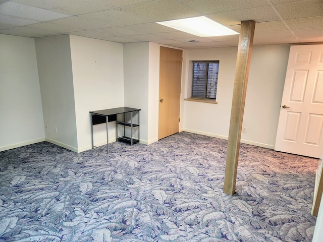 basement with carpet and a paneled ceiling