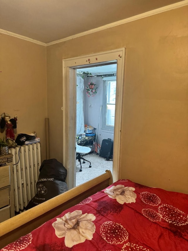 carpeted bedroom featuring crown molding and radiator