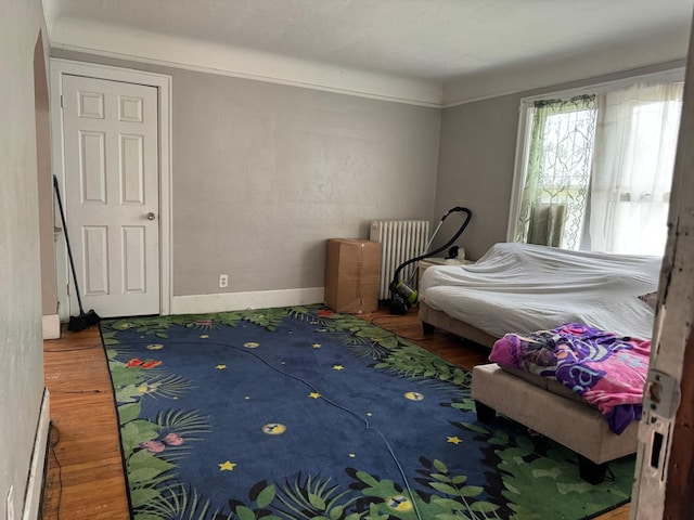 bedroom featuring wood-type flooring and radiator