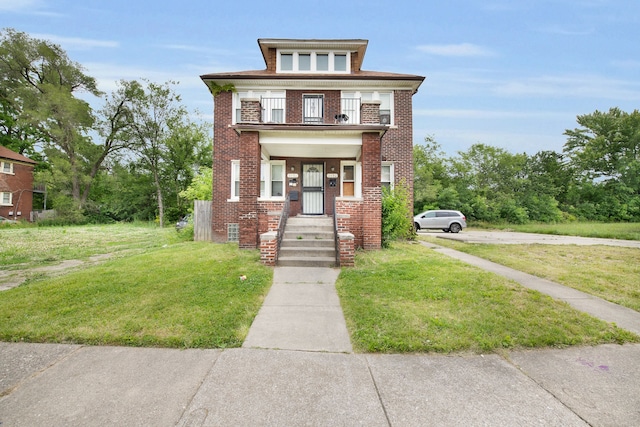 view of front of house featuring a balcony and a front lawn