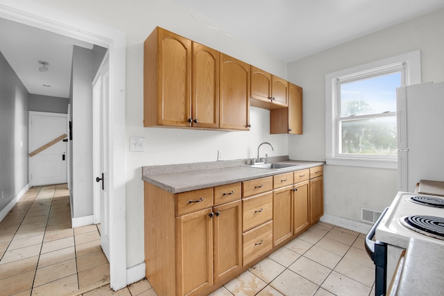 kitchen with light tile patterned floors, white appliances, and sink