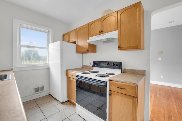 kitchen featuring light wood-type flooring, white appliances, sink, and light brown cabinetry