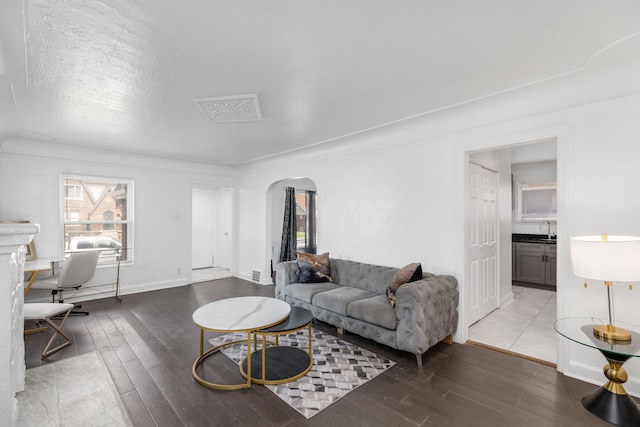 living room with sink, wood-type flooring, and a textured ceiling