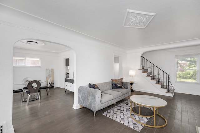 living room featuring a wealth of natural light and dark wood-type flooring