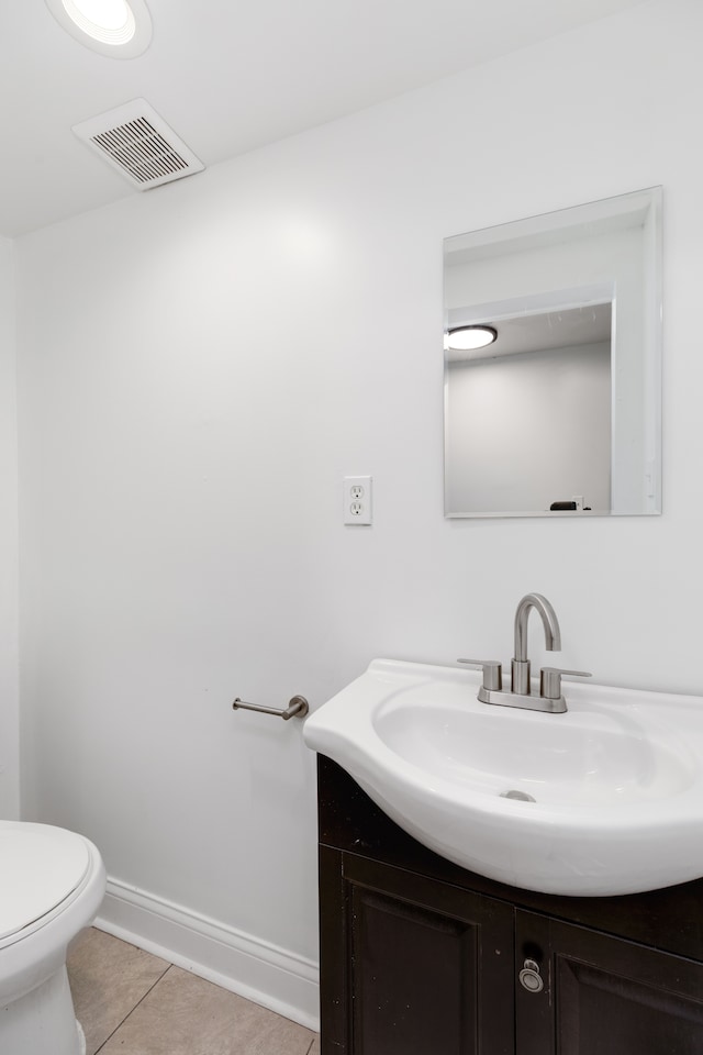 bathroom with tile patterned flooring, vanity, and toilet