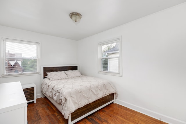 bedroom with dark hardwood / wood-style floors