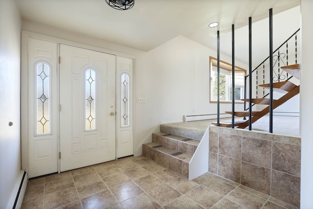 foyer entrance featuring stairway, stone finish floor, and a baseboard radiator