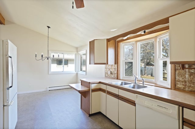 kitchen with light countertops, lofted ceiling, baseboard heating, white appliances, and a sink