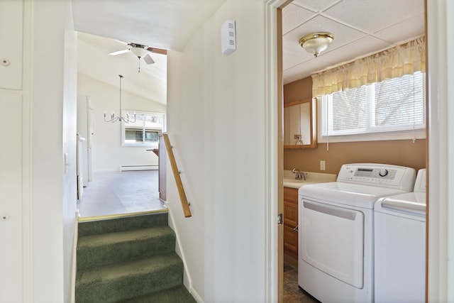 laundry room with a ceiling fan, baseboards, a baseboard radiator, a sink, and washer and dryer