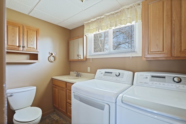 laundry room with laundry area, washing machine and dryer, baseboards, and a sink