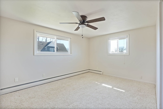 carpeted spare room with a baseboard heating unit, baseboards, and a ceiling fan