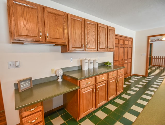 204 W Hatmaker Rd, Coldwater, MI 49036 - kitchen featuring dark countertops, brown cabinetry, and dark flooring