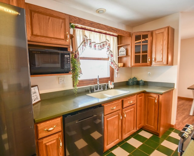 204 W Hatmaker Rd, Coldwater, MI 49036 - kitchen featuring black appliances, tile patterned floors, glass insert cabinets, and brown cabinets