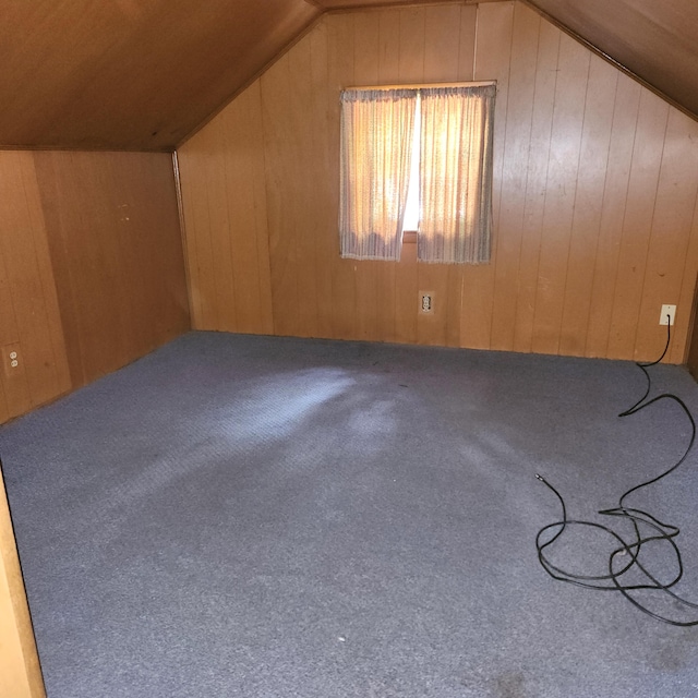 additional living space featuring carpet floors, vaulted ceiling, wood ceiling, and wood walls