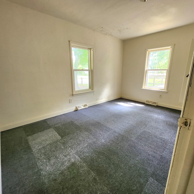 spare room featuring dark colored carpet