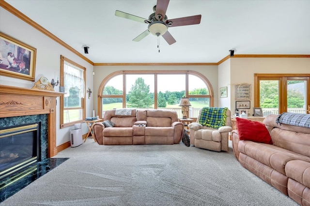 carpeted living room featuring a healthy amount of sunlight, ornamental molding, and a high end fireplace