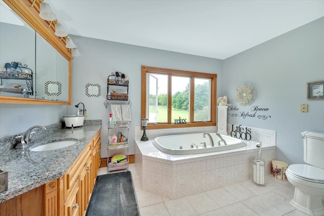 bathroom with tile patterned floors, vanity, toilet, and tiled bath