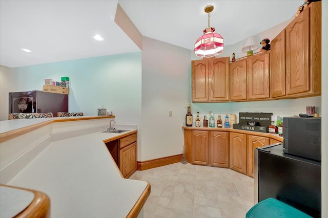 kitchen featuring sink, kitchen peninsula, and hanging light fixtures