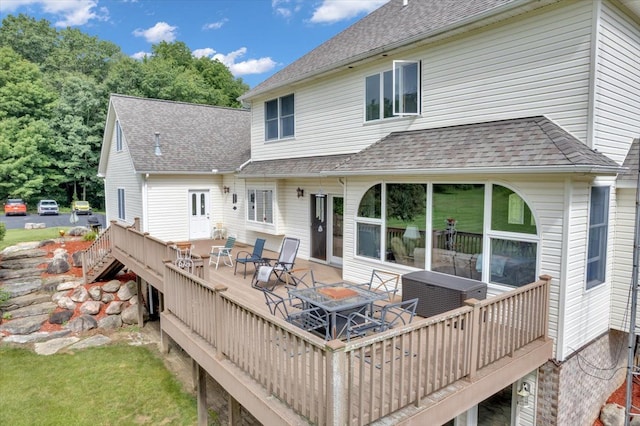 rear view of property featuring a wooden deck