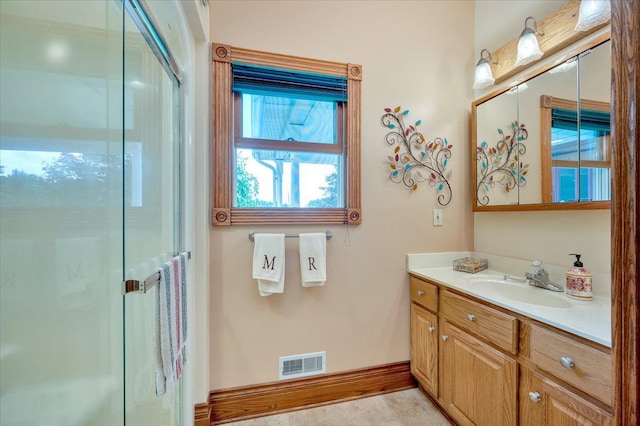 bathroom with vanity and a shower with shower door