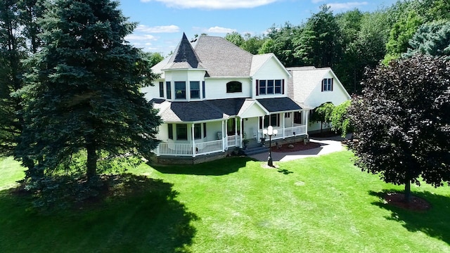 rear view of house featuring a porch and a lawn