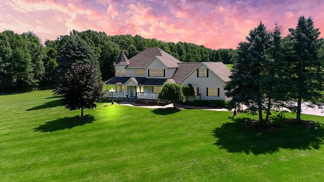 view of front of house featuring a porch and a yard