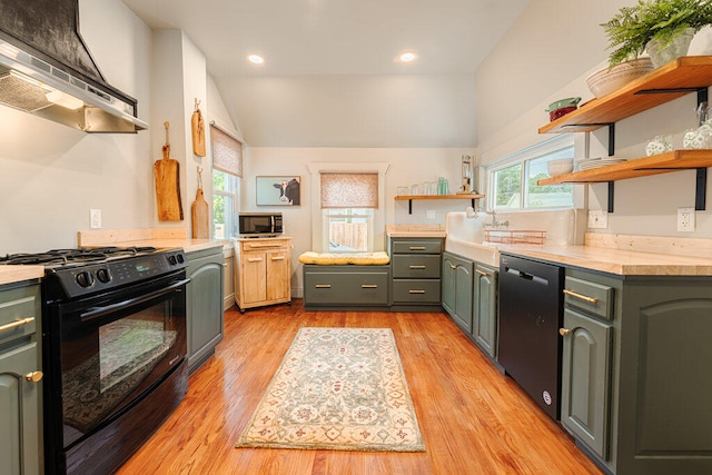 kitchen featuring vaulted ceiling, black appliances, extractor fan, and light hardwood / wood-style floors