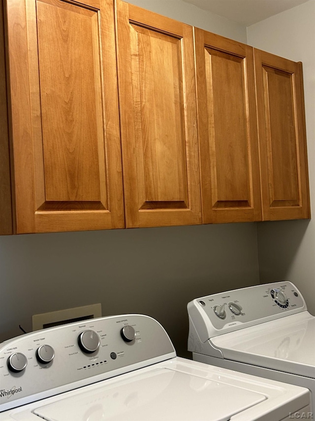 washroom featuring washer and dryer and cabinets