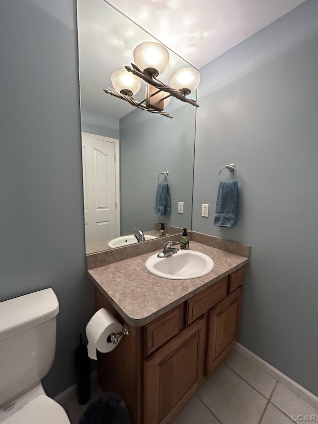 bathroom featuring toilet, vanity, tile patterned floors, and a notable chandelier