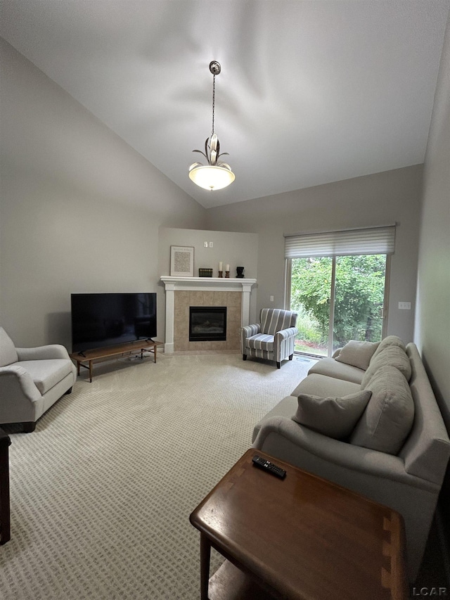 living room featuring lofted ceiling, a tiled fireplace, and carpet floors