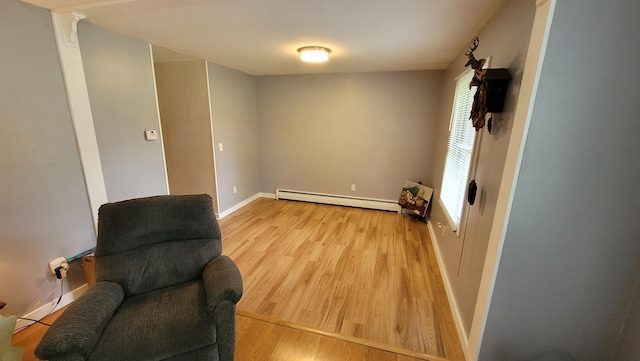 living area featuring light wood-type flooring and a baseboard heating unit