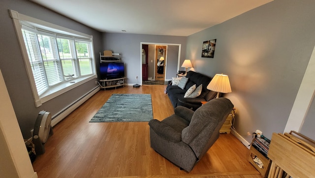 living room featuring baseboard heating and light hardwood / wood-style flooring