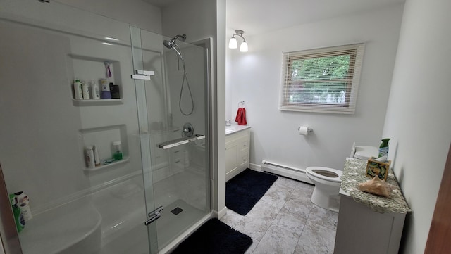 bathroom with vanity, toilet, a shower with door, and a baseboard heating unit