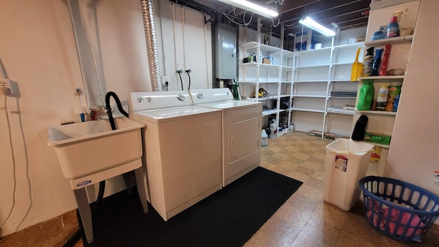 clothes washing area featuring washer and dryer, electric panel, and sink