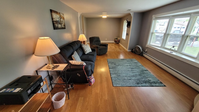 living room featuring wood-type flooring and a baseboard heating unit