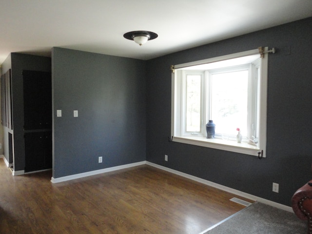 spare room with dark hardwood / wood-style floors