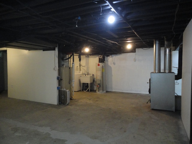 basement with sink, washer / clothes dryer, and water heater