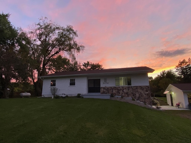 view of front of house featuring a yard and an outbuilding